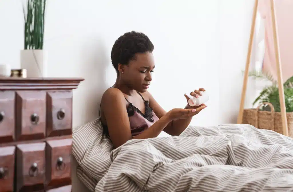 Mujer en la cama que necesita medicación para el dolor.