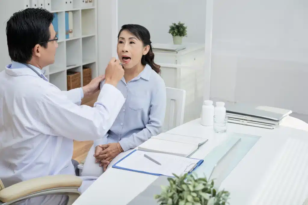 Mujer consulta al médico síntomas de herpes labial.